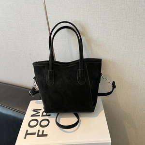 Classic black faux suede bucket bag with dual handles and adjustable crossbody strap