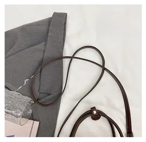 Detail of the slim dark brown leather shoulder strap with refined edge oil finish