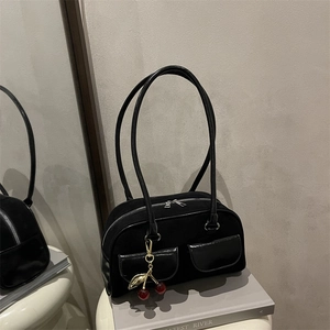Retro black suede underarm bag with glossy dual pockets and a cherry charm detail