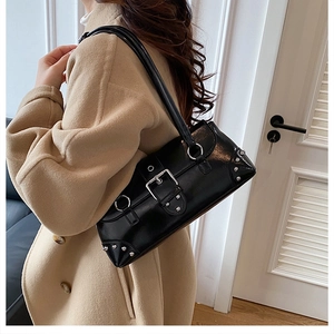 Detail der schwarzen Lackleder-Schultertasche mit silbernen Nieten und Metallschnallen