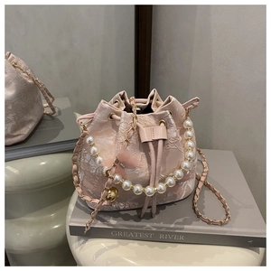 Sac seau rose en dentelle avec poignée en perles et bandoulière en chaîne dorée