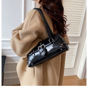 Retro-Biker-Baguette-Tasche mit silbernen Nieten und Schnalle am Modell im Mantel