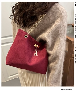 Close-up of burgundy frosted tote bag with gold chain strap and deer pendant detail