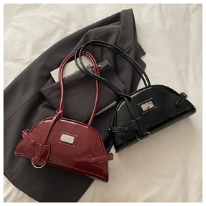 Flat lay of glossy patent leather crescent bags in burgundy and black colors