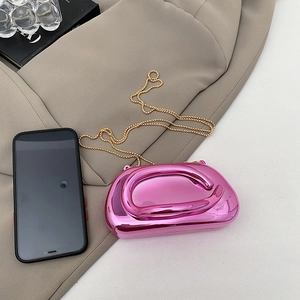 Mini metallic pink clutch bag with gold chain shown next to a smartphone for size