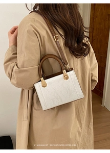 Vue arrière d'un mannequin portant un sac rétro minimaliste avec un trench-coat kaki