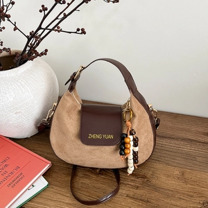 Minimalist khaki suede saddle bag with dark brown leather details and beaded charm decoration