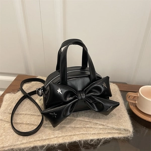 Black Y2K bow handbag with silver star rivets on soft beige fur background