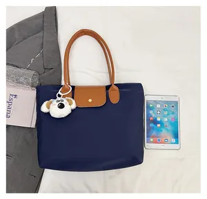 Navy nylon tote bag size comparison with tablet, brown leather handles and puppy charm