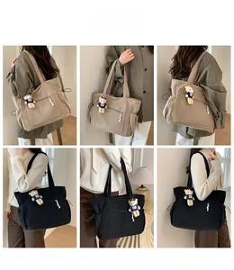 Vue détaillée du grand sac cabas en velours côtelé avec cordons latéraux et pendentif ours