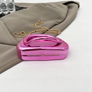 Detail of metallic mirror pink clutch bag with streamlined handle and gold chain strap