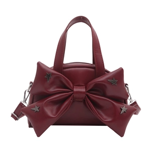 Burgundy bucket bag with bow detail and star studs, featuring a handle and chain strap