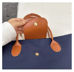 Detail of high-quality golden magnetic snap closure on navy nylon and leather tote bag