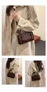 Detailed view of dark brown glossy leather shoulder bag with vertical fashion embossing