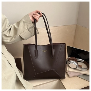 Détail d'un grand sac cabas en cuir marron avec lettrage doré pour le bureau