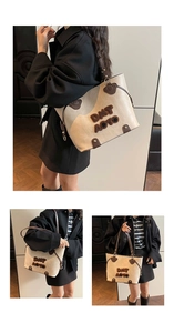 Detail of cream tote bag with brown leather straps and plush DMT AOTO letter patches