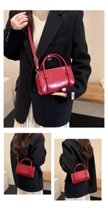 Detail view of bright red leather tote with dual handles and Fashion engraving