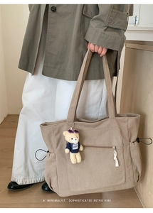 Détail du sac cabas en velours avec poche latérale à cordon et pendentif ours