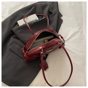 Macro view of burgundy patent leather handbag showing spacious interior and silver hardware