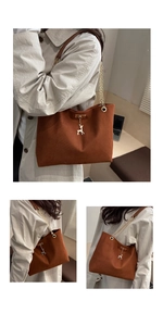 Detail of caramel tote bag featuring golden deer charm and elegant chain shoulder strap
