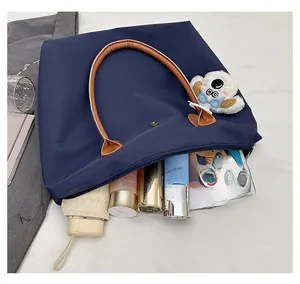 Close-up of a deep blue tote bag interior showing large capacity for umbrella and phone