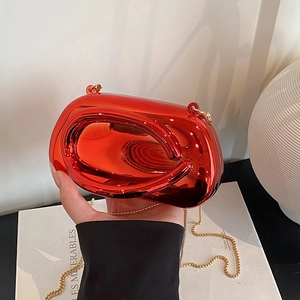 Detail of red metallic clutch bag with unique circular handle and gold chain strap