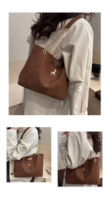 Detail of coffee tote bag with golden deer charm and chain shoulder strap leather