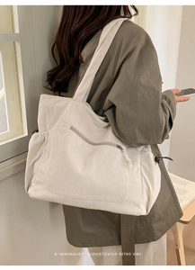 Detail of minimalist corduroy tote bag with side zipper pocket in ivory white