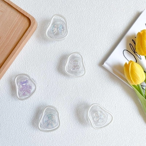 Detail showing various cute resin charms on phone grips with bear and flower patterns