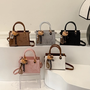 Trendsetting textured crossbody bags in multiple colors with cute plush kitty pendants