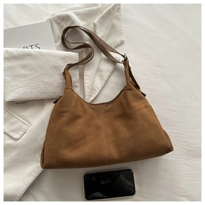 Detail of vintage brown suede tote bag with vertical stitching and adjustable leather strap