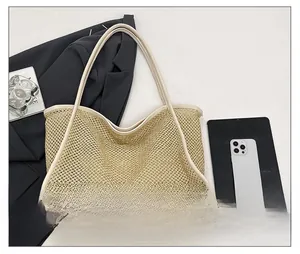 Detail of woven metallic tote bag featuring cream leather trim and long shoulder straps