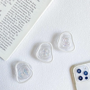 Detailed view of three aurora resin phone grips in bear, flower, and abstract shapes