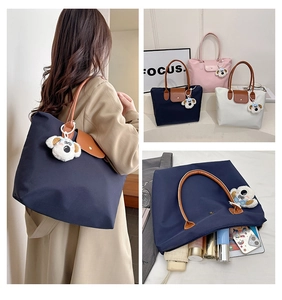 Detailed view of spacious nylon tote bag with leather handles and cute plush dog charm