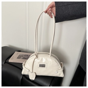 Detailed view of off-white PU leather Boston bag with metal plate and slim shoulder straps