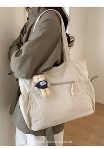 Detail of off-white corduroy tote bag texture with zipper pocket and cute bear pendant