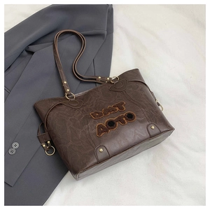 Detail of vintage brown tote bag with suede letter embroidery and metallic hardware