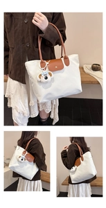 White large tote bag with brown leather handles and a cute white dog plush pendant detail