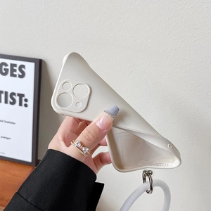 Close-up of flexible cream silicone iPhone case with metal ring and lanyard attachment