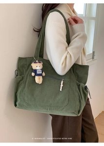 Vue détaillée du sac cabas en velours côtelé vert forêt avec texture et breloque ours