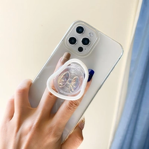 Detail of white heart-shaped phone grip with iridescent gold butterfly on clear case