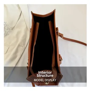 Vista de la estructura interna del bolso tote marrón con tres compartimentos y un cremallera