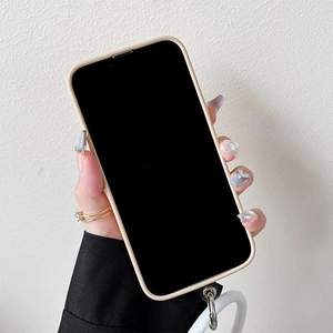 Close-up of beige iPhone case featuring a silicone wrist strap and metal connectors
