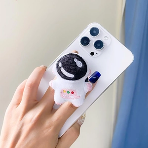 Detail showing hand holding a cute white plush astronaut phone grip on a smartphone