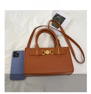 Borsa a mano in pelle marrone con fibbia a cuore dorata e tracolla con scala dimensionale