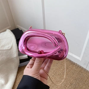Detail of bright pink metallic clutch bag with unique hollow handle and gold chain strap