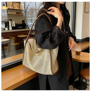 Detail of hand-woven straw tote with premium brown leather trim and handle straps