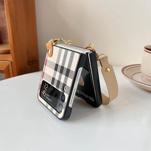 Detail of Galaxy Z Flip case featuring beige plaid pattern and leather hand strap chain