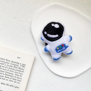 Close-up of a cute plush astronaut phone grip featuring colorful embroidered details