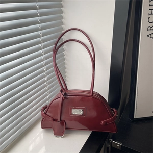 Chic burgundy leather crescent armpit bag with glossy finish and silver metal plate